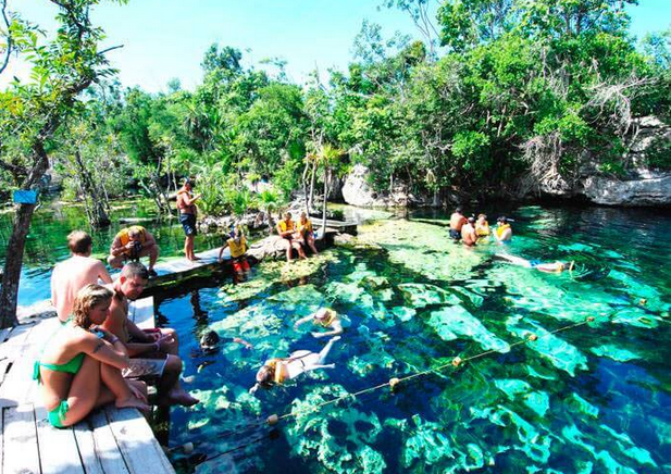 turistas nadando en un cenote en la riviera Maya