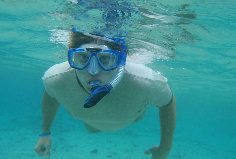 Hombre joven bajo el agua practicando snorkel