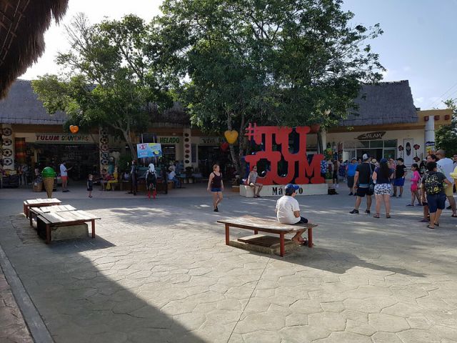 Para dor turistico en el centro de Tulum con letras rojas de #Tulum