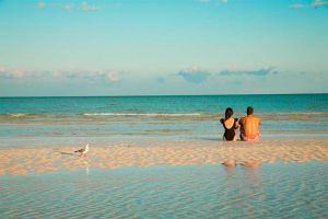 pareja sentada en la playa de holbox